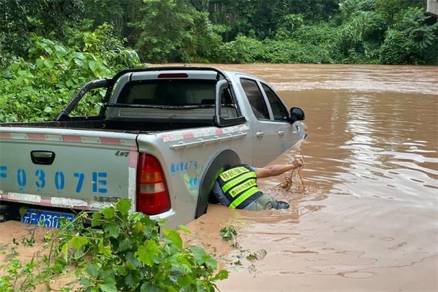 身上绑着安全绳手里拿着拖车绳，他三度扎进湍急洪水